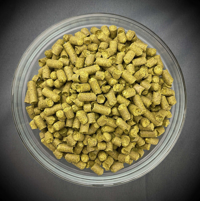 Bowl of fresh Alora Hops Pellets with a dark background.