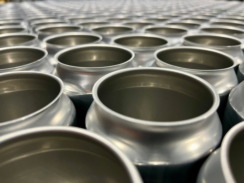 A closeup view of the empty cans on a pallet, looking off into the distance actross hundreds of cans.