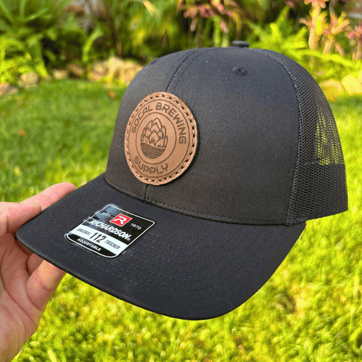 SoCal Brewing Supply Hat with Leather Laser Engraved Logo, the hat is all black in color, side angle view.