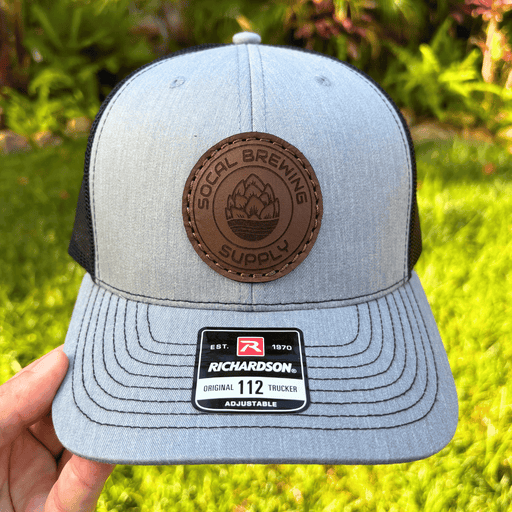 Gray and black SoCal Brewing Supply cap with a brown leather patch and Richardson logo, held against a grassy background.